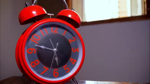 Time-Lapse of a Large Red Vintage Twin-Bell Clock on a Wooden Table 動画素材 337901034