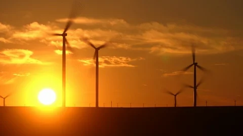 Time lapse of a large wind turbine in a field against a background of orange Video stock 125861050