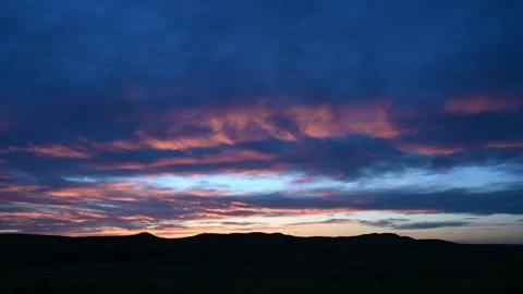 Time lapse of late day blue colored clouds that start out with pink highlights  Stock Footage 281184663