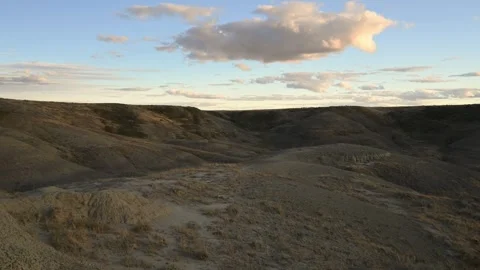 Time lapse of late day yellowish clouds moving across a blue sky above a very dr Stock Footage 268925722