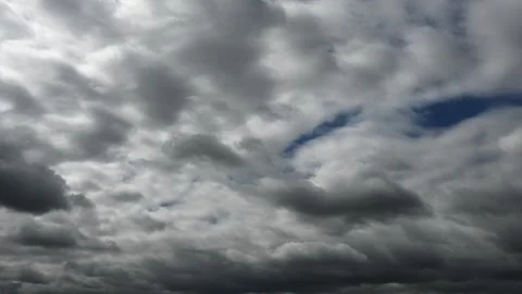 Time lapse of light to dark gray rain clouds moving through a dark blue sky Stock Footage 321951553
