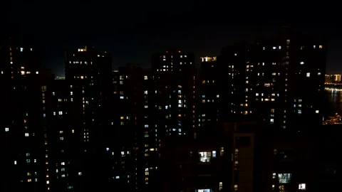 Time lapse of light in the windows of a multistorey apartment buildings at late Stock Footage 148478197