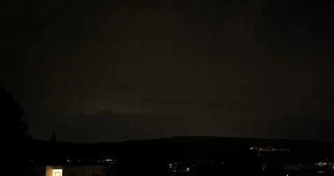 Time lapse of lightning over a hillside village and residential area at night Stock Footage 345026695