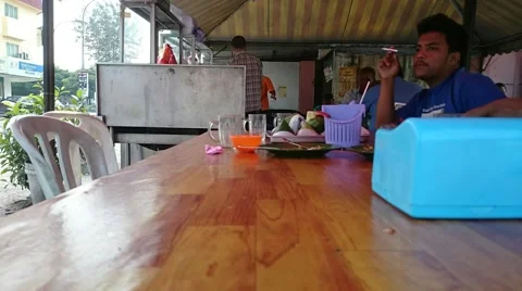 Time lapse of a lonely man smoking cigarette and thinking in a small food stall Stock Footage 41448352