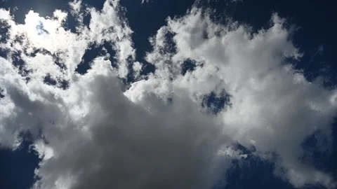 Time lapse looking up at a dark blue summer sky as clouds pass in front the sun Stock Footage 281184679