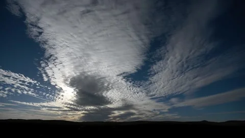 Time lapse looking towards the sun of dramatic morning clouds above distant hill Stock Footage 286902874