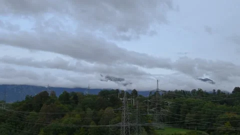 Time lapse of low altitude clouds rolling over forest and Alps mountains Stock Footage 140183174