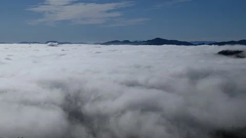 Time lapse low altitude inversion clouds rolling in valley Stock Footage 140799778