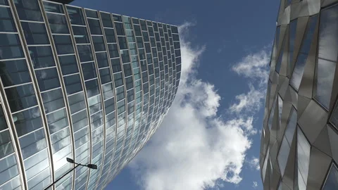 Time lapse.  A low angle view of a clouds reflected on a glass skyscraper. Stock Footage 220516881