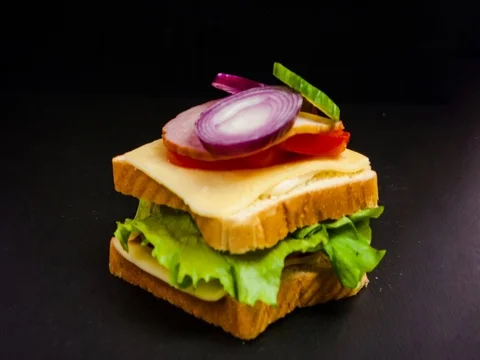 Time lapse of making a big sandwich with tomato, ham, cheese and salad. Stock Footage 80786458