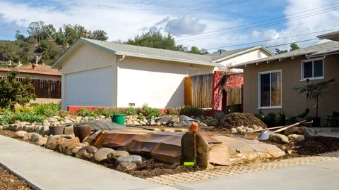 Time-lapse of a man building a rock wall in front of a house in Oak View, Stock Footage 107568299