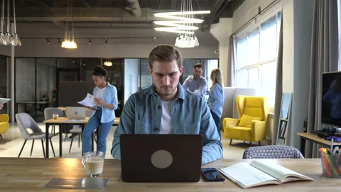 Time-lapse of man employee working in office using laptop while coworkers moving Stock Footage 171789525