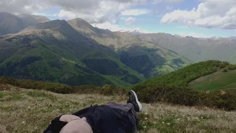 Time-lapse of man lying on lawn with panorama of italian alps Stock Footage 279850949