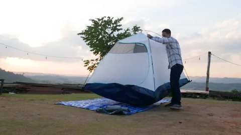 Time-lapse of a man set up tent at campsite Stock Footage 310782475