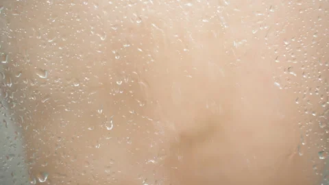 Time-Lapse of Man Showering Behind Water-Droplet Covered Glass, Background Out Stock Footage 277125018