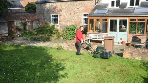 Time lapse man using lawnmower in garden Stock Footage 54576063