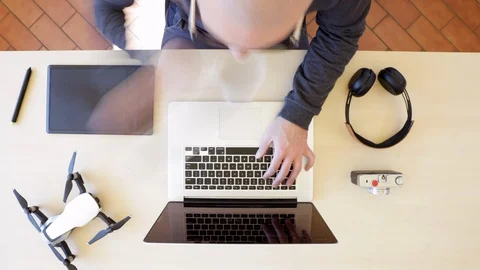 Time lapse of man working from home with his laptop on a wooden desk. Top view Stock Footage 127642033