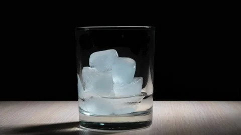 Time lapse of melting ice cubes in glass with black background Stock Footage 181933258