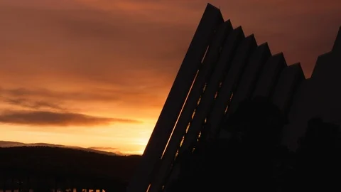 Time lapse of midnight sun behind Tromso Artic Cathedral silhouette Video stock 113733623