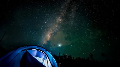 Time Lapse of Milky Way with passing clouds over tent Видео 112377643