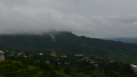 Time lapse of mist floating over mountains with village on the foreground Stockbeeldmateriaal 92671847