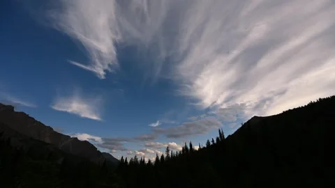 Time lapse of mixed clouds in a blue sky above a V-shaped mountain valley  Stock Footage 247412414
