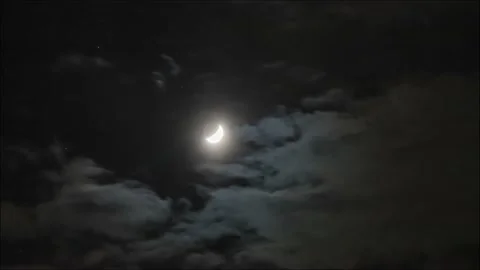 Time lapse: the moon lighting through clouds in dark night sky Stock Footage 131003396