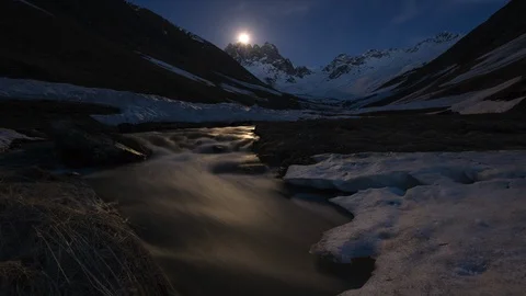 Time-lapse of moon, mountain valley and river. moonrise. snow-capped mountains Stock Footage 114977699