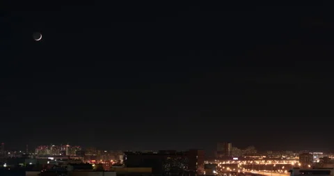 Time lapse of the moon moving across the sky over a city in the night lights Stock-Footage 287215575