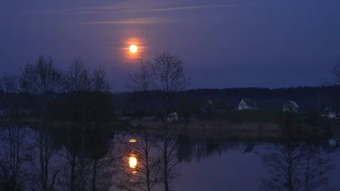 Time lapse of the moon rising reflecting on the surface of the water. Vidéo 103742680
