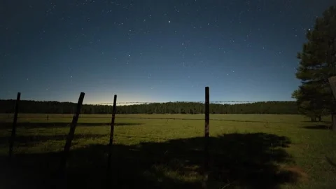 Time lapse of moon shadows and stars above a ranch grassland Stock Footage 249777452