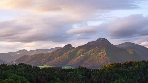 Time lapse motion of fast clouds over misty alps mountain peak in sunny spring Stock-Footage 201161225