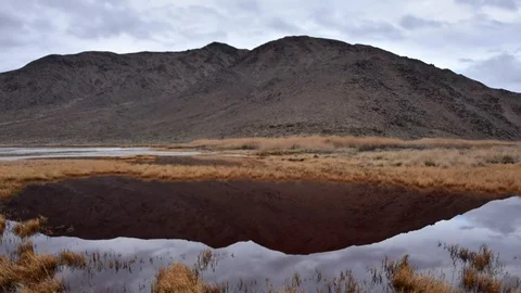 Time lapse mountain and clouds reflecting on water in desert Video stock 72247981