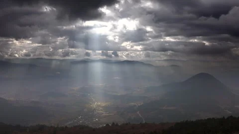 Time lapse from mountain peak as sun rays break through clouds - Flat Landscape Stock Footage 339556121