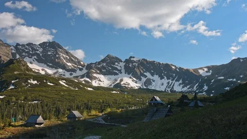 Time lapse Mountain range peaks with snow, village and hikers Stock Footage 121551250