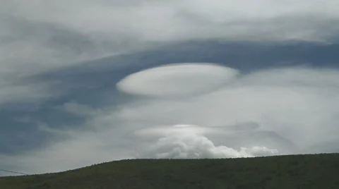 Time Lapse of Mountain Wave UFO Clouds above Hillside Stock Footage 54728939