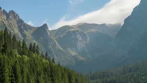 Time lapse mountains, peaks, mountain range rolling clouds in blue sky Stock Footage 163380594