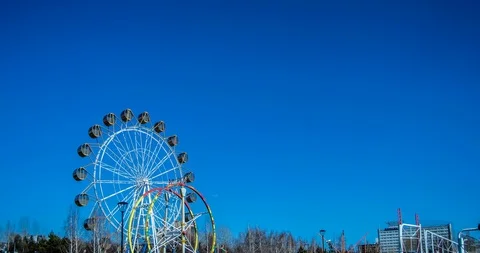 Time lapse of the movement of a round Ferris wheel in a city central park Stock-Footage 129542420