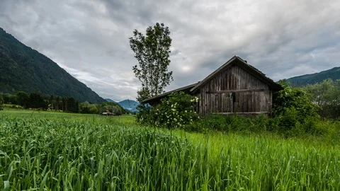 Time lapse - Moving clouds above an old farm house Видео 99370578