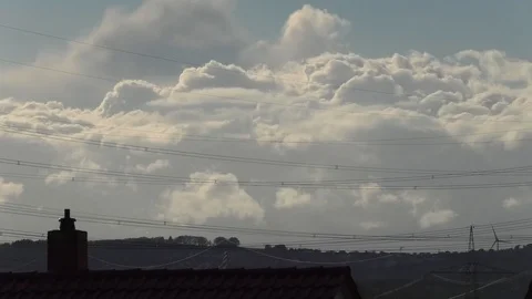 Time Lapse: Moving clouds and sunset in rural village, tiled roof, power lines Stock Footage 107086954