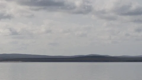 Time-lapse of moving clouds and tranquil landscape with calm water bay Stock Footage 123282439
