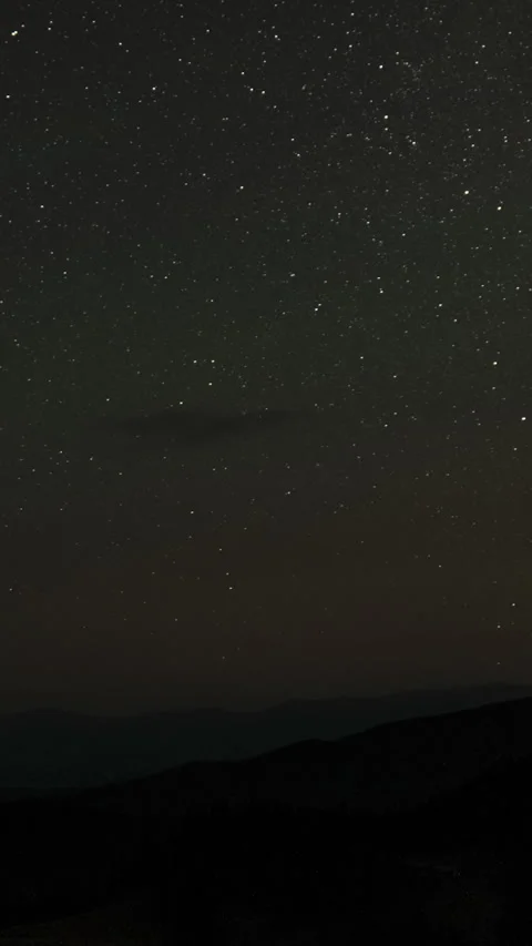 Time lapse of moving clouds and stars over the mountains in the night sky Stock Footage 292615514