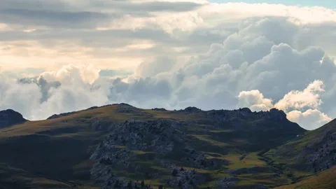 Time lapse of moving clouds lit by the sunset light behind mountain top Stock Footage 247471432