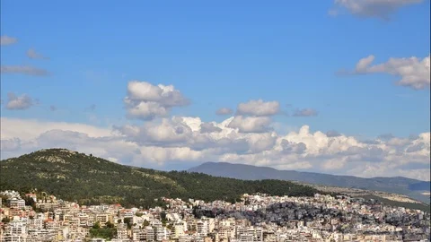 Time lapse of moving clouds over hill and city. Stock Footage 112512013