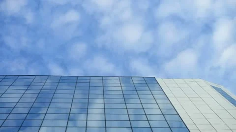Time lapse moving clouds reflected in the windows of the skyscraper. Stock Footage 11428970