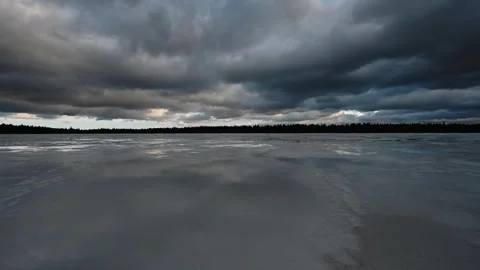 Time lapse of moving clouds reflecting in pools of water on a frozen lake.  Stock Footage 256105102
