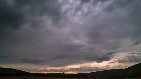 Time lapse of moving gray clouds under over firs tops of mountain forest Stock Footage 75835356