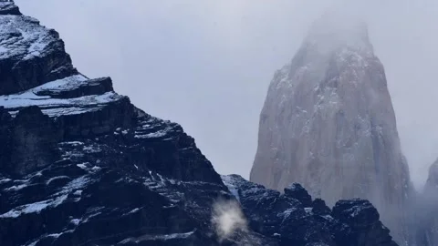 Time lapse of moving white clouds hiding and showing the top of mountains in Stock Footage 264758804
