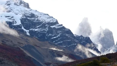 Time lapse of moving white clouds hiding and showing the top of mountains and Stock Footage 264758927