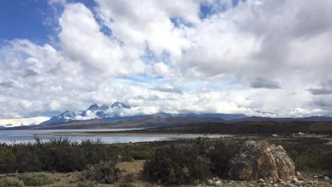 Time lapse of moving white clouds above a lake and mountains in the national Stock Footage 264808451